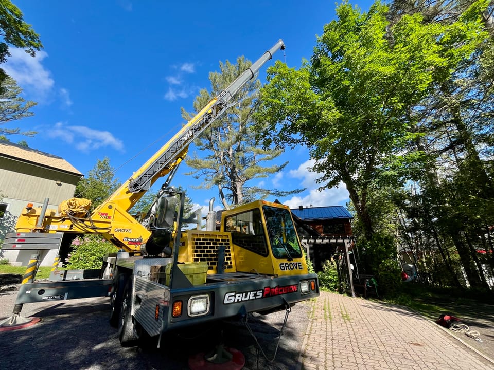 Grue installée dans une entrée pour l’abattage d’un grand arbre